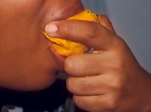 Sexy ebony mouth playing with a mango
