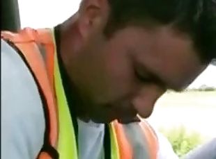 A worker in a reflective jacket sucks himself in his work car